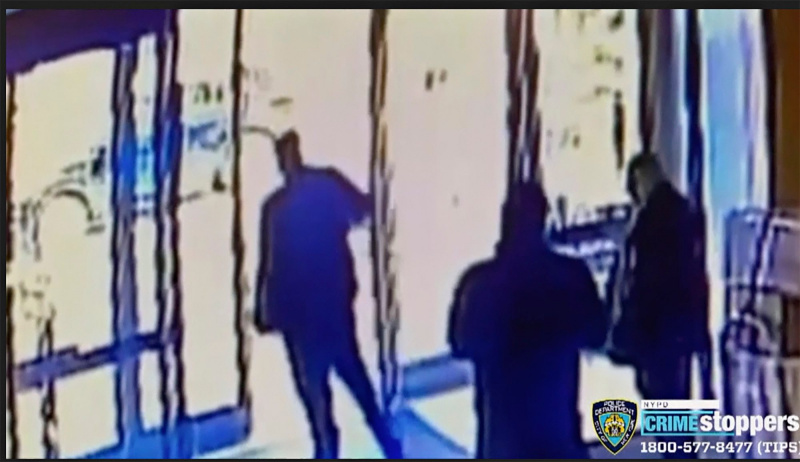 Dieses Bild aus einem Überwachungsvideo der New Yorker Polizeibehörde zeigt einen Mitarbeiter eines Wohnhauses in der Mitte, der das Gebäude schließt