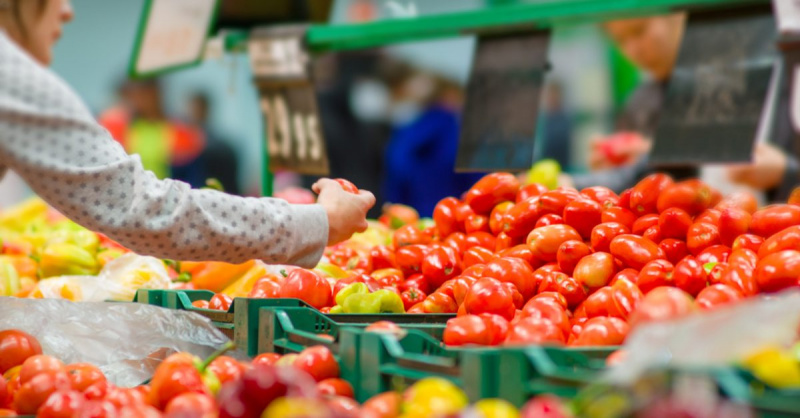 Kunden, die Tomaten im Supermarkt auswählen
