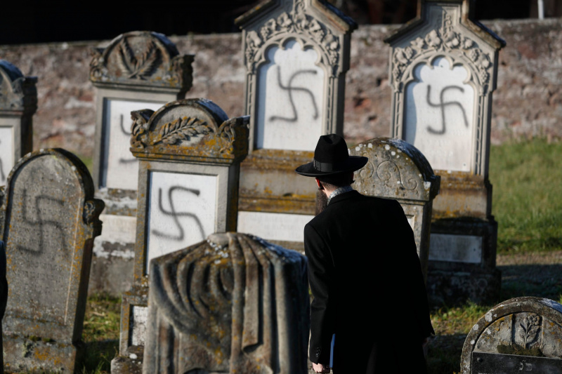 ФАЙЛ - На этой фотографии из архива от 4 декабря 2019 года главный раввин Страсбурга Гарольд Абрахам Вайль смотрит на оскверненные гробницы на еврейском кладбище Вестхоффен к западу от Страсбурга на востоке Франции. Блокировка коронавируса в 2020 году сместила некоторую антисемитскую ненависть в Интернете, где появилось множество теорий заговора, обвиняющих евреев в медицинских и экономических разрушениях, израильские исследователи из Тель-Авивского университета